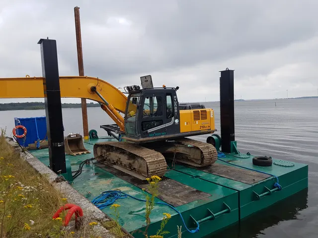 Green spud pontoon with Hyundai excavator on board