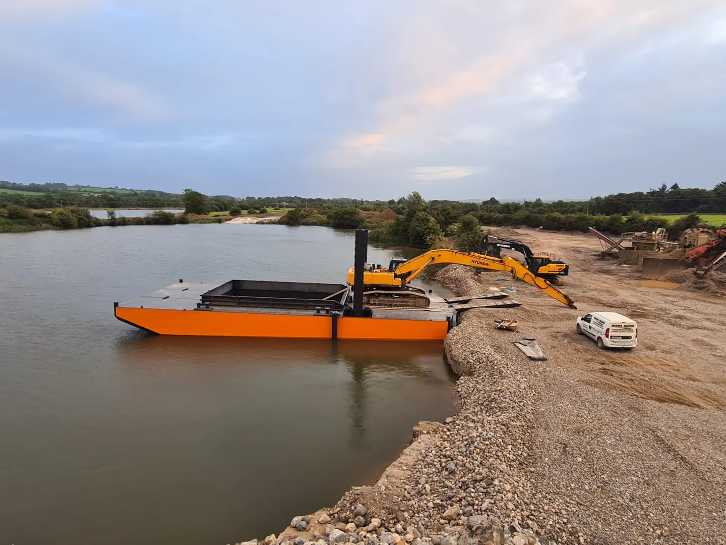 Steel work barge on calm water with crane and equipment on deck