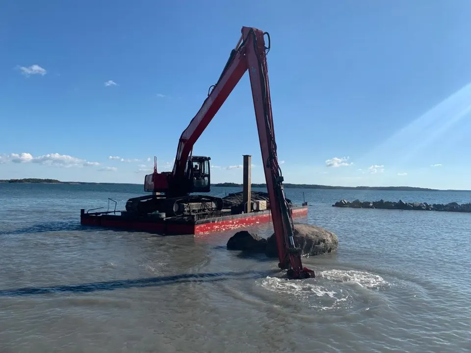 Stalmar steel dredging barge with excavator in full operation on open water